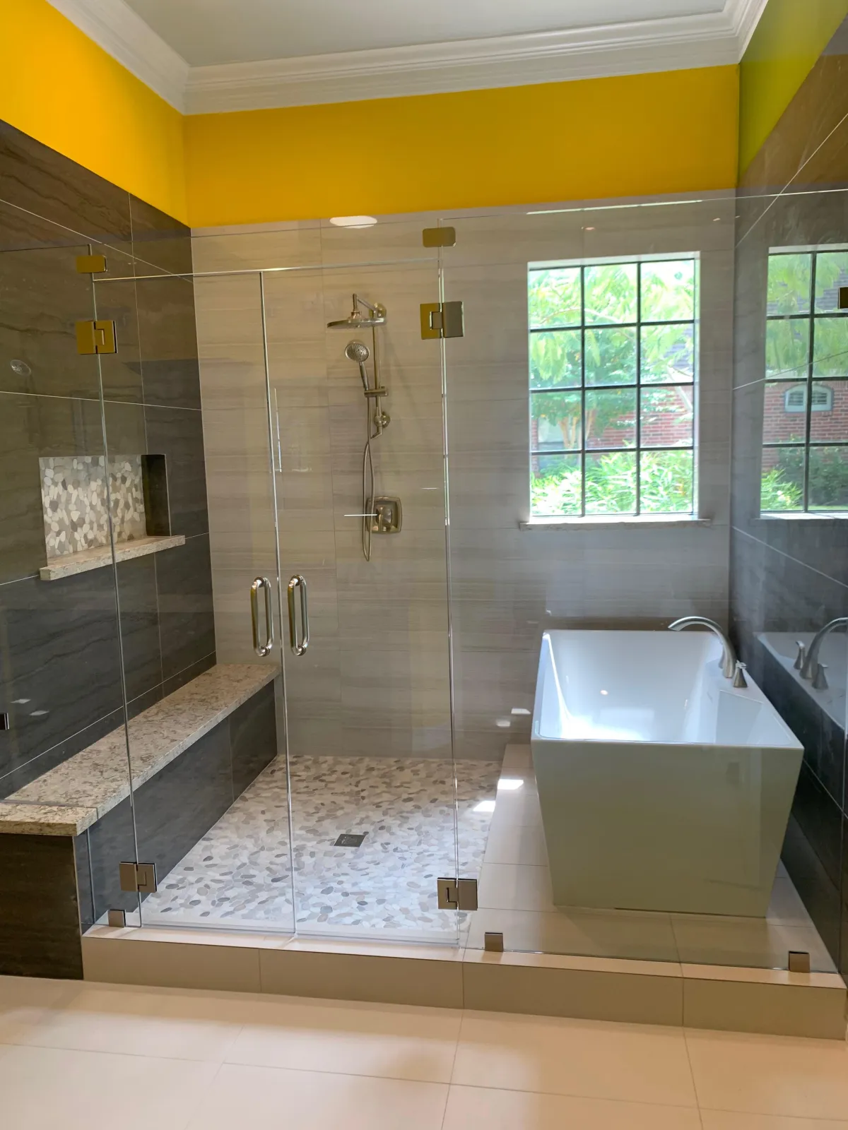 Modern bathroom remodel with frameless glass shower enclosure and upgraded tile design in Pensacola Florida