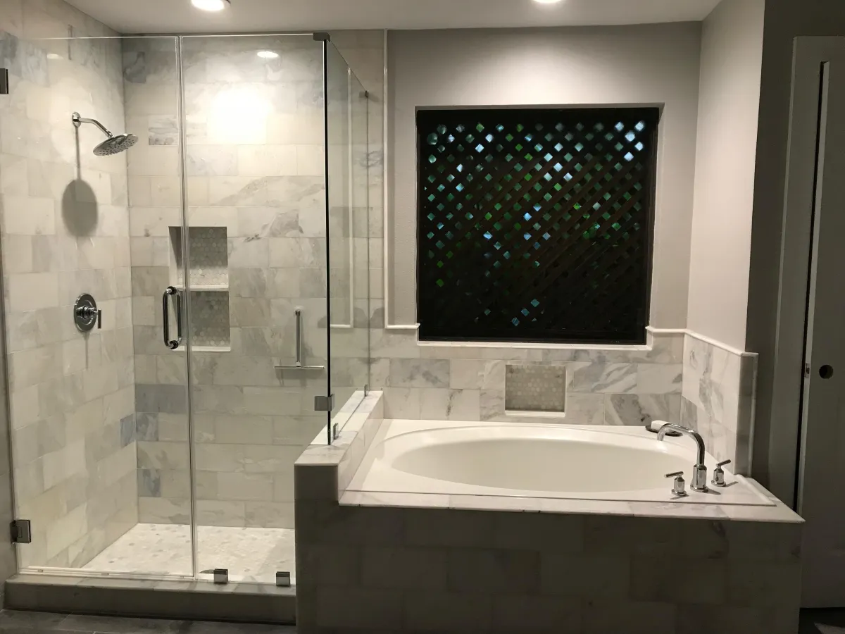 After image of a Gulf Breeze bathroom remodel featuring a frameless glass shower enclosure, modern tile, and elegant fixtures