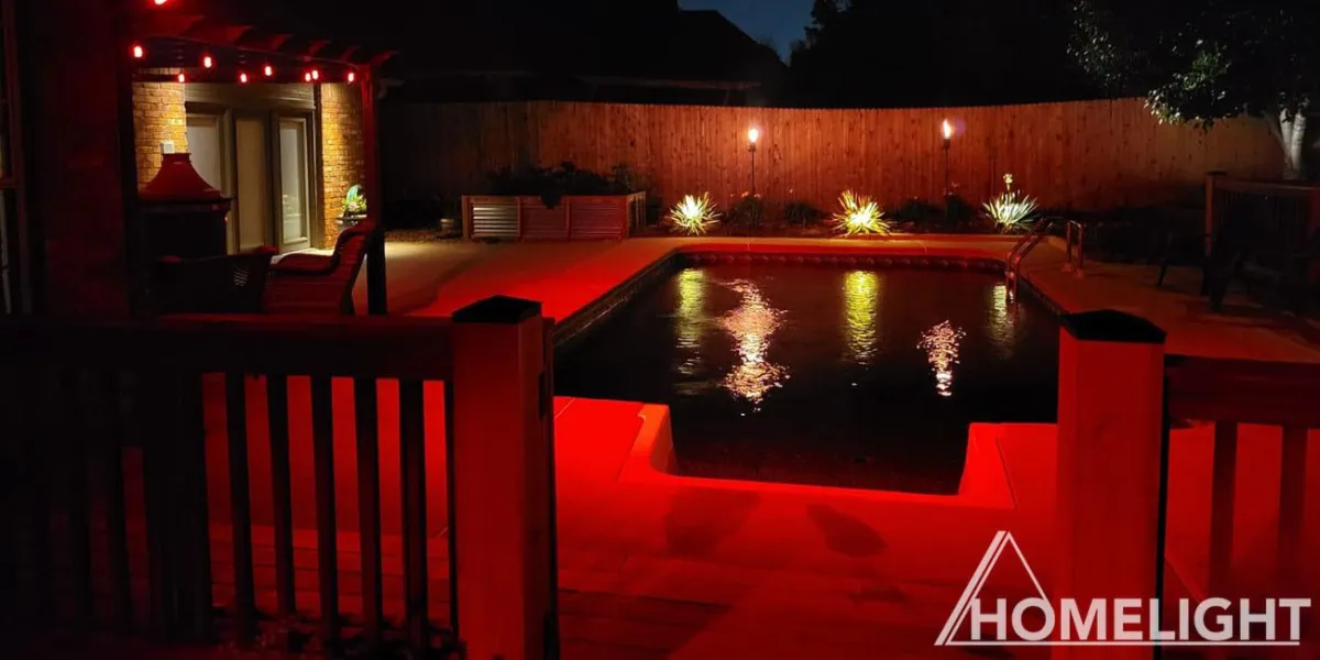 In this Residential Backyard Oasis, a warm red glow provides an inviting and tranquil atmosphere. The Pool reflects the the various lights, creating an enchanting ambiance.