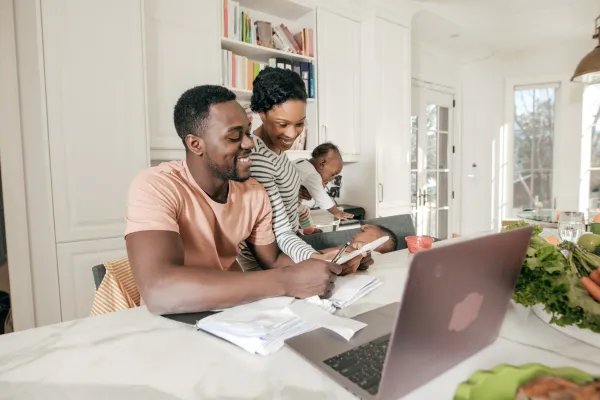 Family sitting at table with laptop