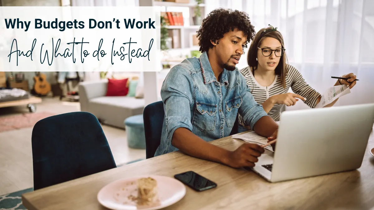 A couple sitting at their kitchen table with a laptop, reviewing their budget with a hopeful expression — representing clarity and peace with money