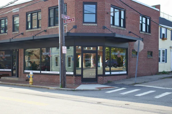 Front entrance of Scuttlebutt Barbershop in Portsmouth, NH with anchor logo on windows and door