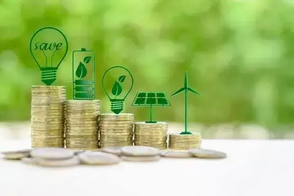 Stacked coins with green energy icons, symbolizing investment in sustainable energy solutions.