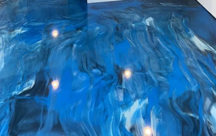 Modern garage with Metallic Epoxy flooring featuring reflective, high-gloss surface and decorative swirl effect.