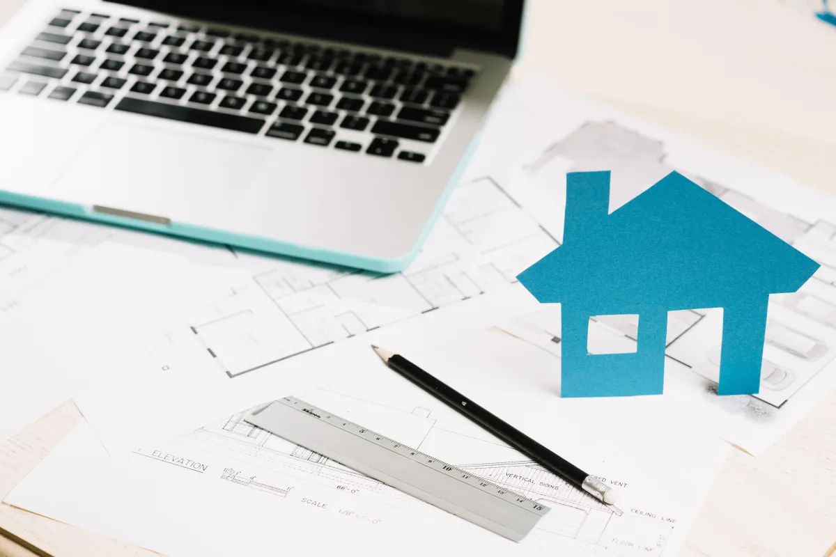 Laptop al costado de un boceto para un proyecto inmobiliario
