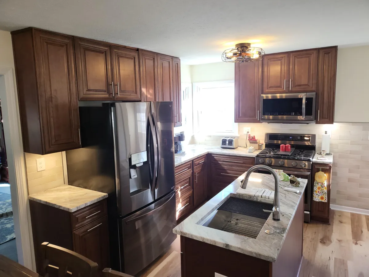 Island kitchen with brown cabinets in a well lit kitchen