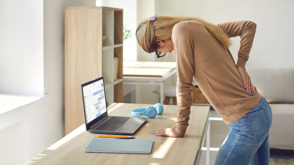 Woman Who Works in Sitting Posture on Her Computer All the Time Suffers from Back Pain