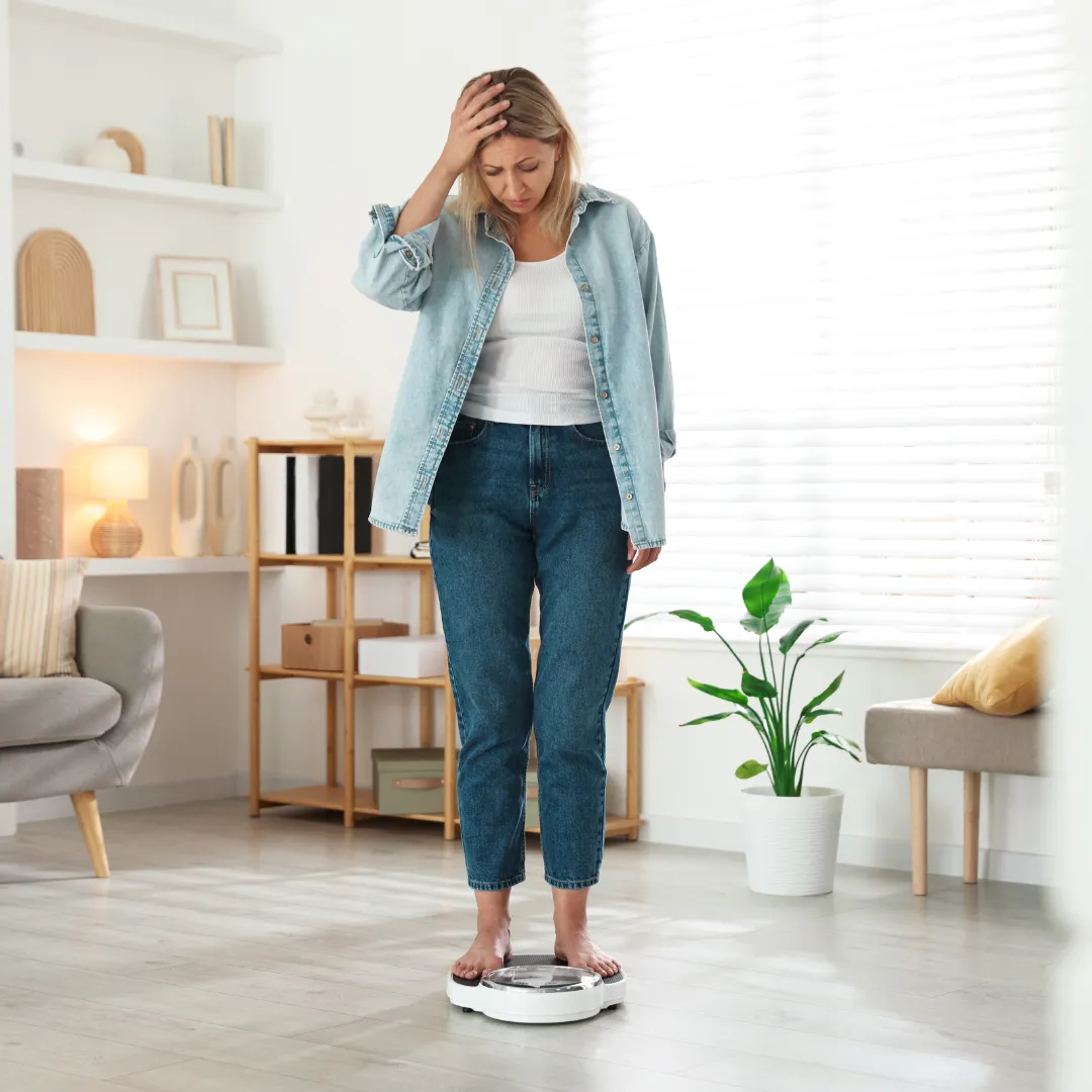 woman on scale looking stressed