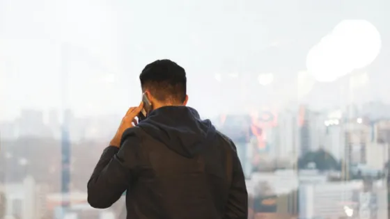 man on phone overlooking city