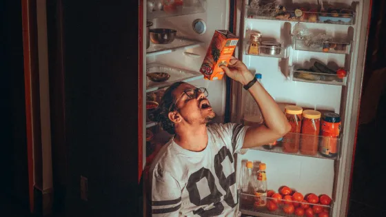 man drinking from OJ carton