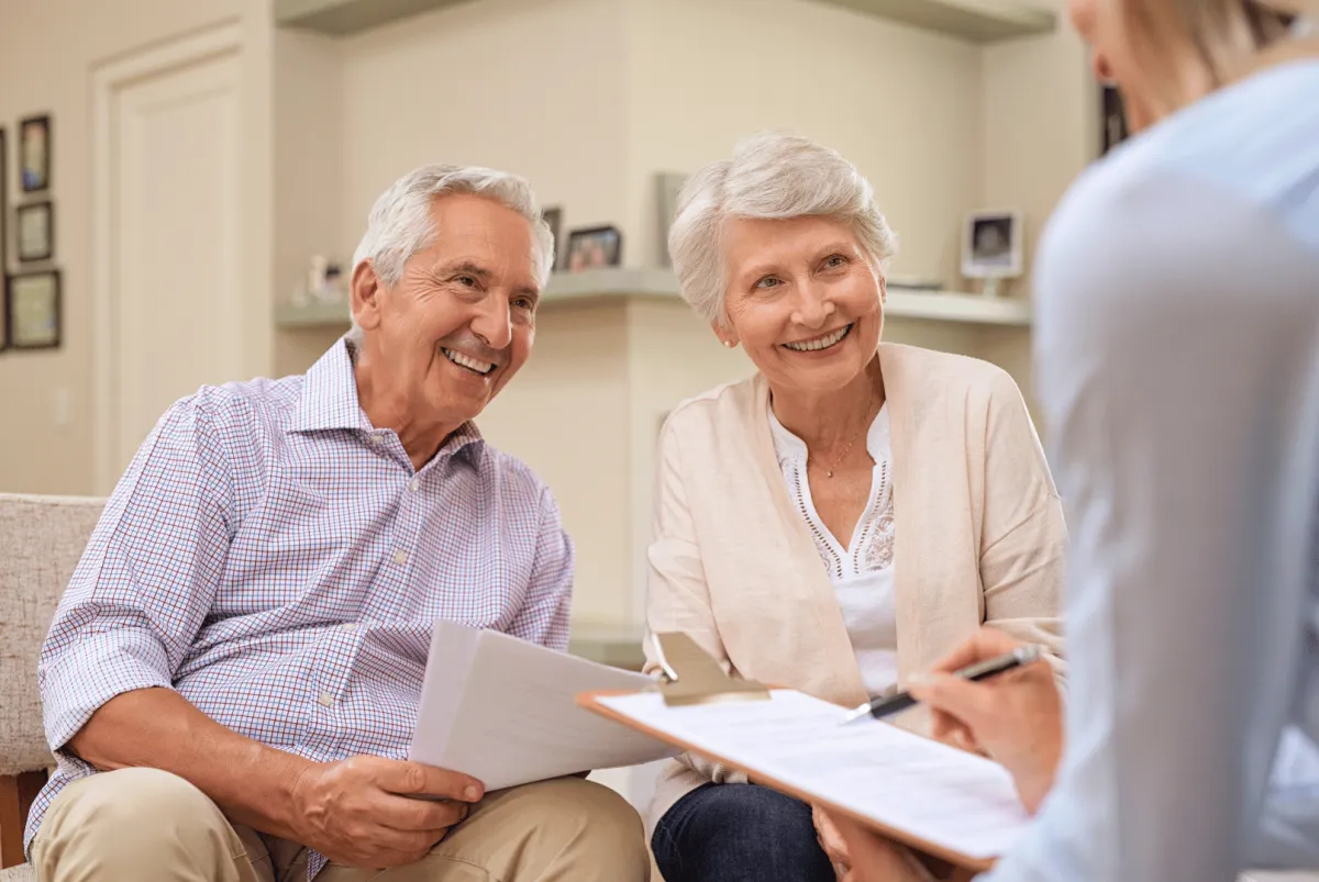 A senior couple discussing financial documents with a financial advisor.