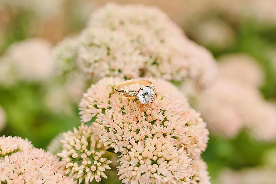 Close-up of a wedding ring with a floral background, captured by Double Knot Photography, showcasing elegant wedding details at Sabrina Cedars in Abilene Texas