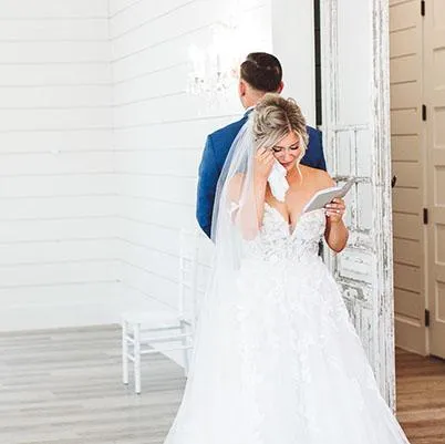 Bride reading a letter at the French Farmhouse, captured by Double Knot Photography, showcasing an emotional wedding moment.