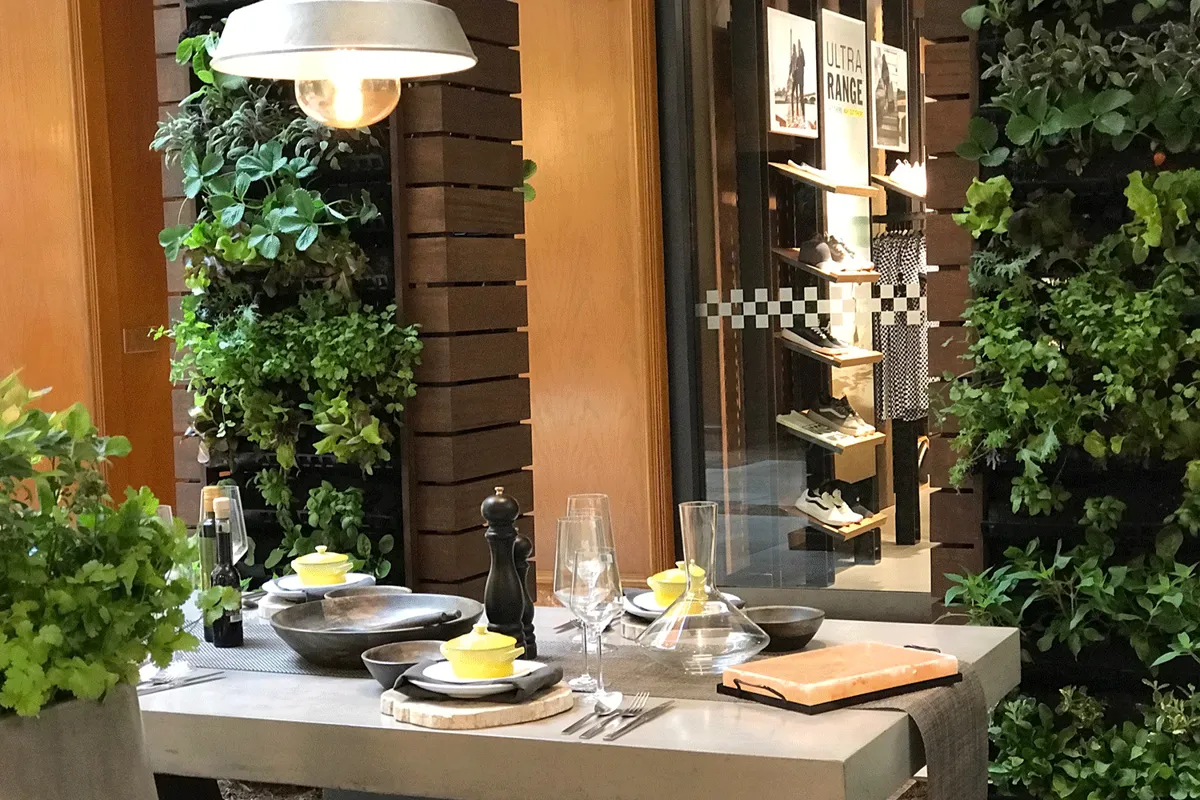 Indoor restaurant dining area with lush vertical garden for ambiance and wellness.