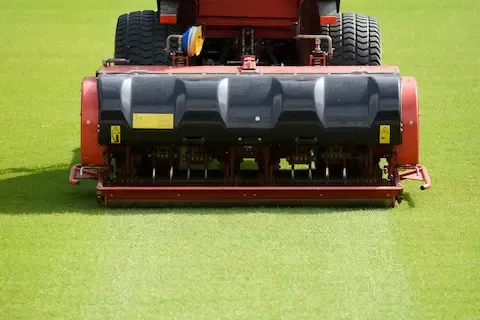 Core aerator machine working across turf for lawn aeration by Apple Valley Lawn and Snow