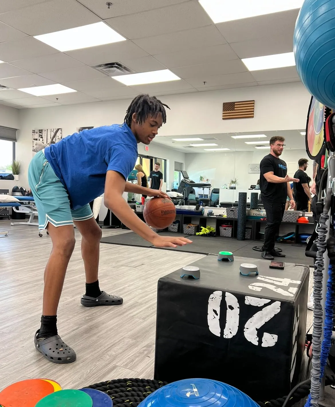 Youth athlete dribbling a basketball during sports performance training session.