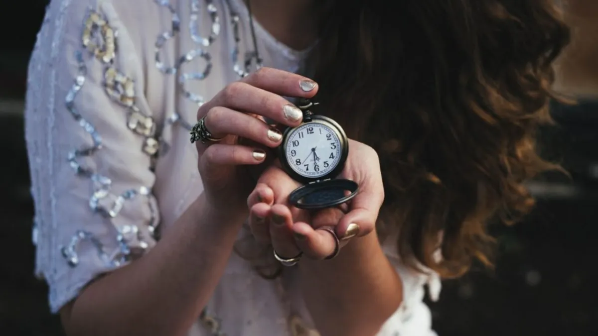 woman holding a pocket watch