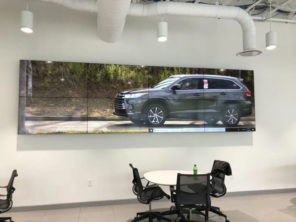 Video wall showcasing various car models in a Birmingham dealership showroom.