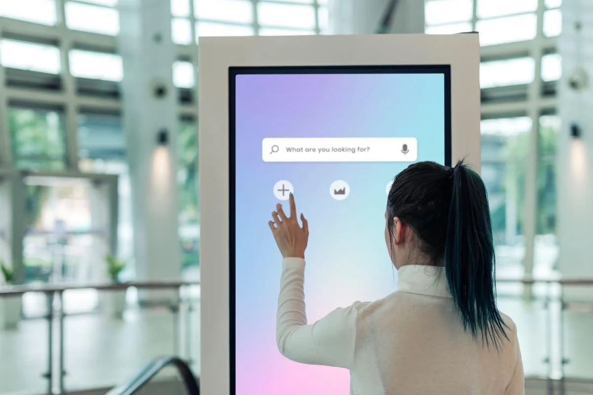 woman searching for information using digital signage kiosk