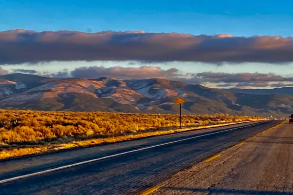 A wide-open road leading into sunlit mountains under a colorful sky—symbolizing clarity, direction, and the journey of building a business with purpose.