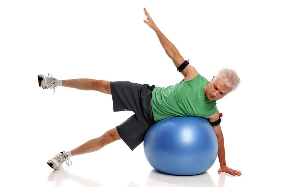 Image of patient exercising on ball with blood flow restriction device