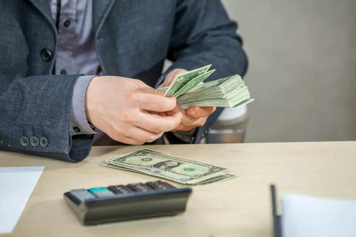 Handshake and money exchange symbolizing a business loan deal.