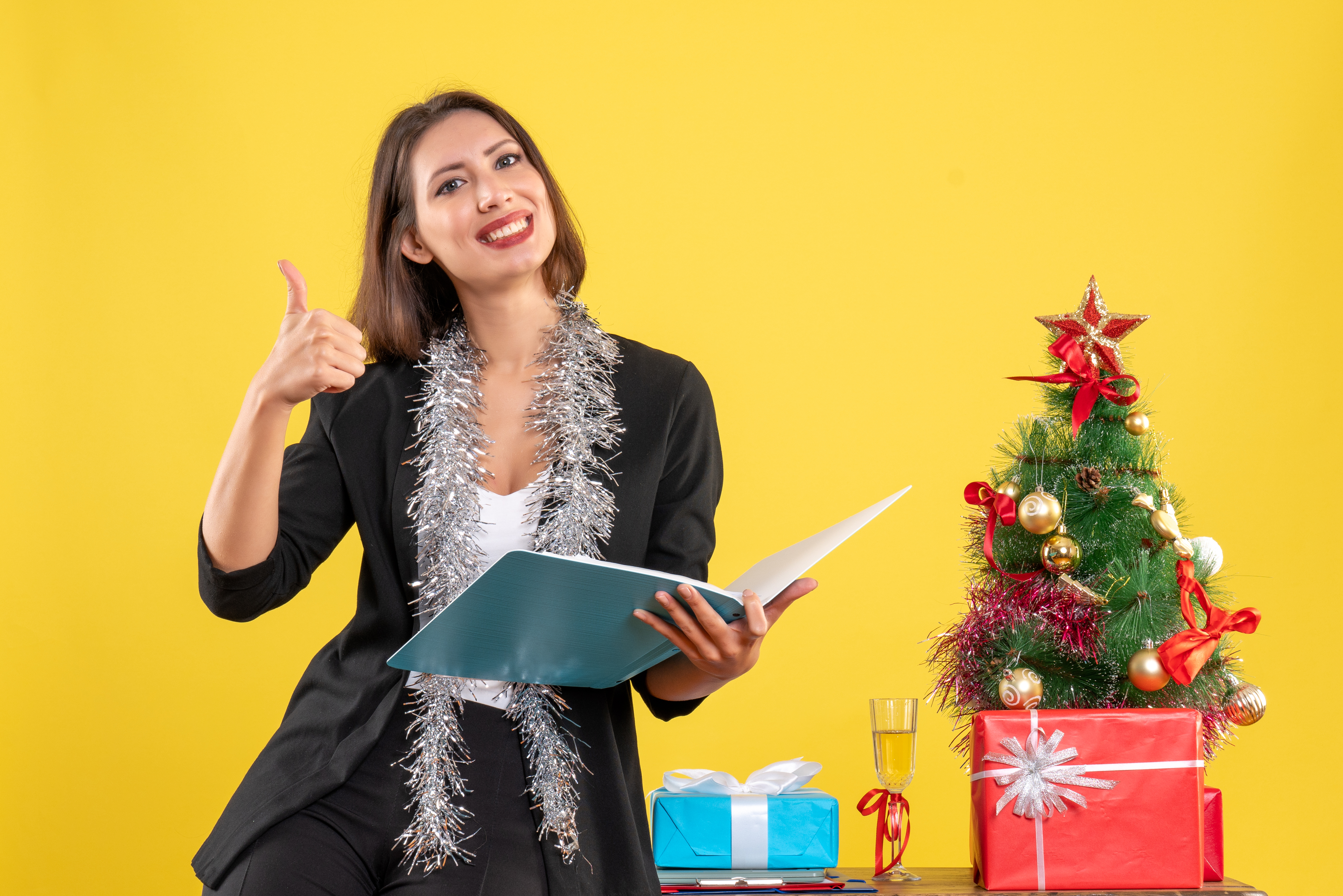 Christmas mood with smiling beautiful lady standing in the office and working alone