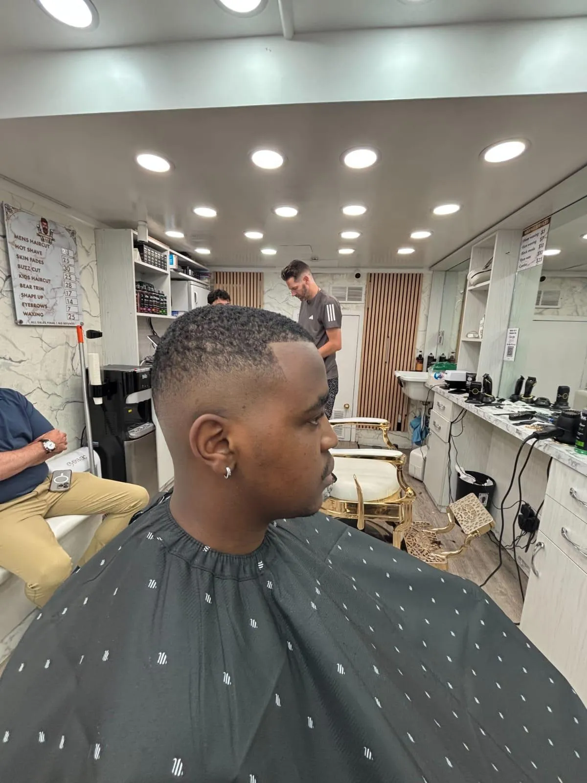 Barber at Imperial Barbershop NYC shaping a client's beard with precision