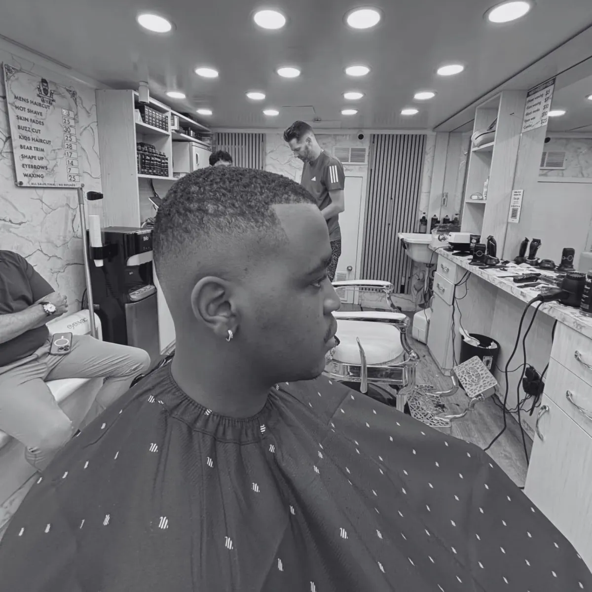 Barber giving a hot towel shave to client at Imperial Barbershop 2 NYC