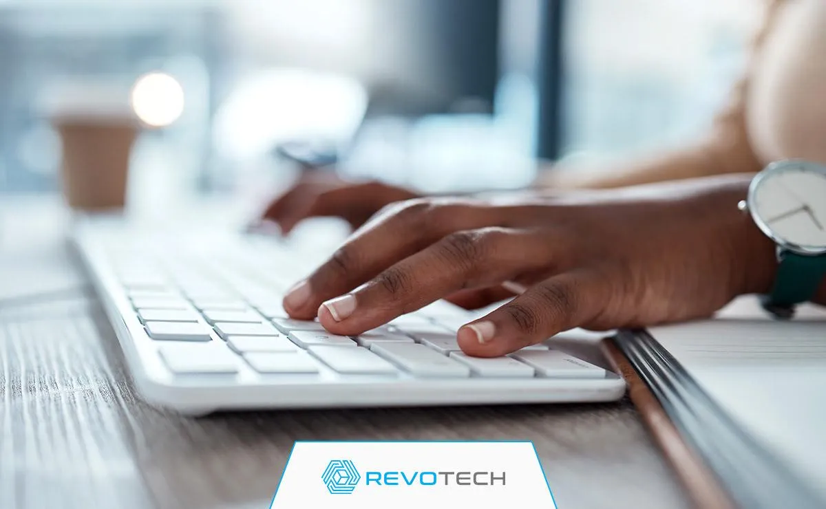 Hands typing on a keyboard, logging a request to the IT help desk.