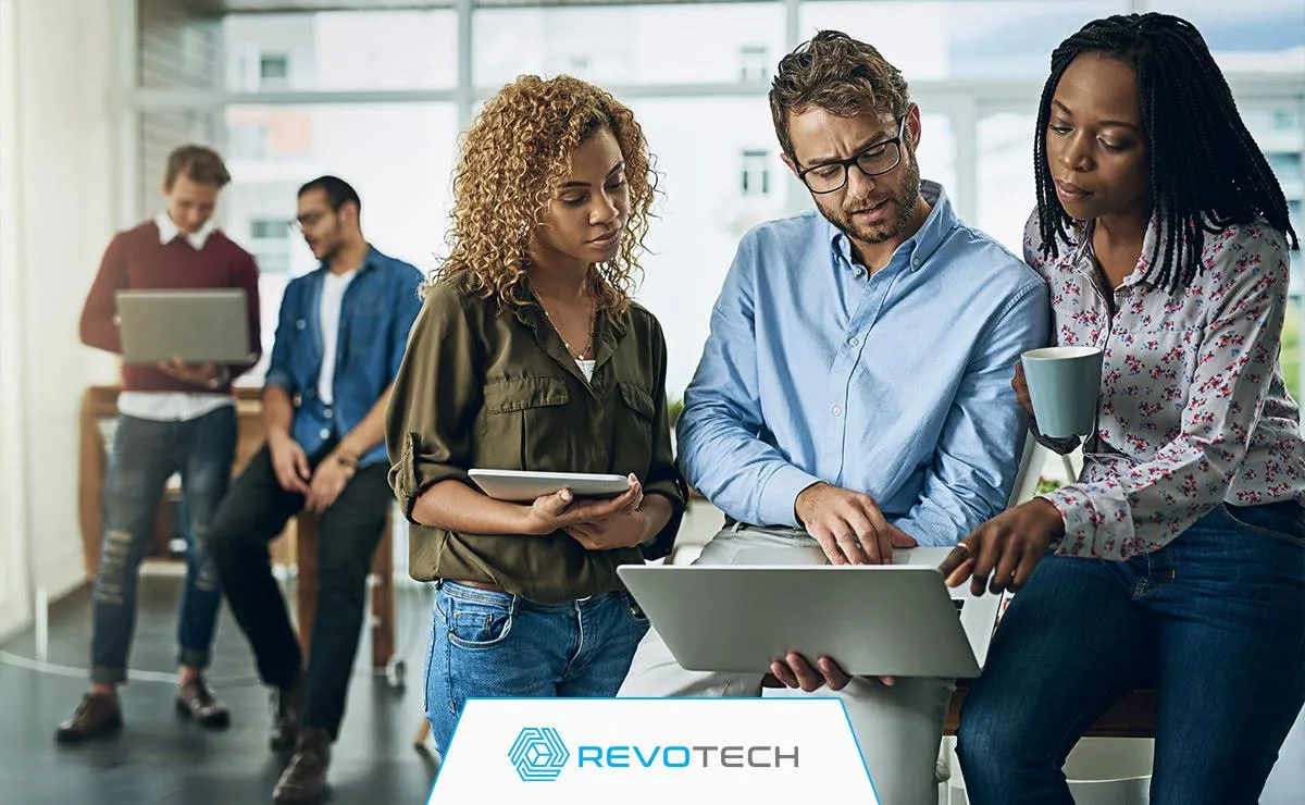 Group of non profit workers looking at laptop trying to solve IT issue