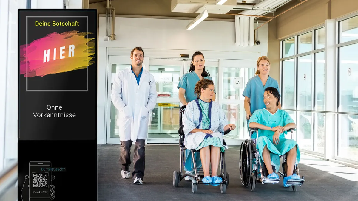 „Digitale TOUCHwall Infostele in einer Klinik – interaktives Display zur Orientierung, Patienteninformation und Anzeige von Wartezeiten oder Hygienehinweisen.“