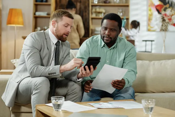 two men looking at papers