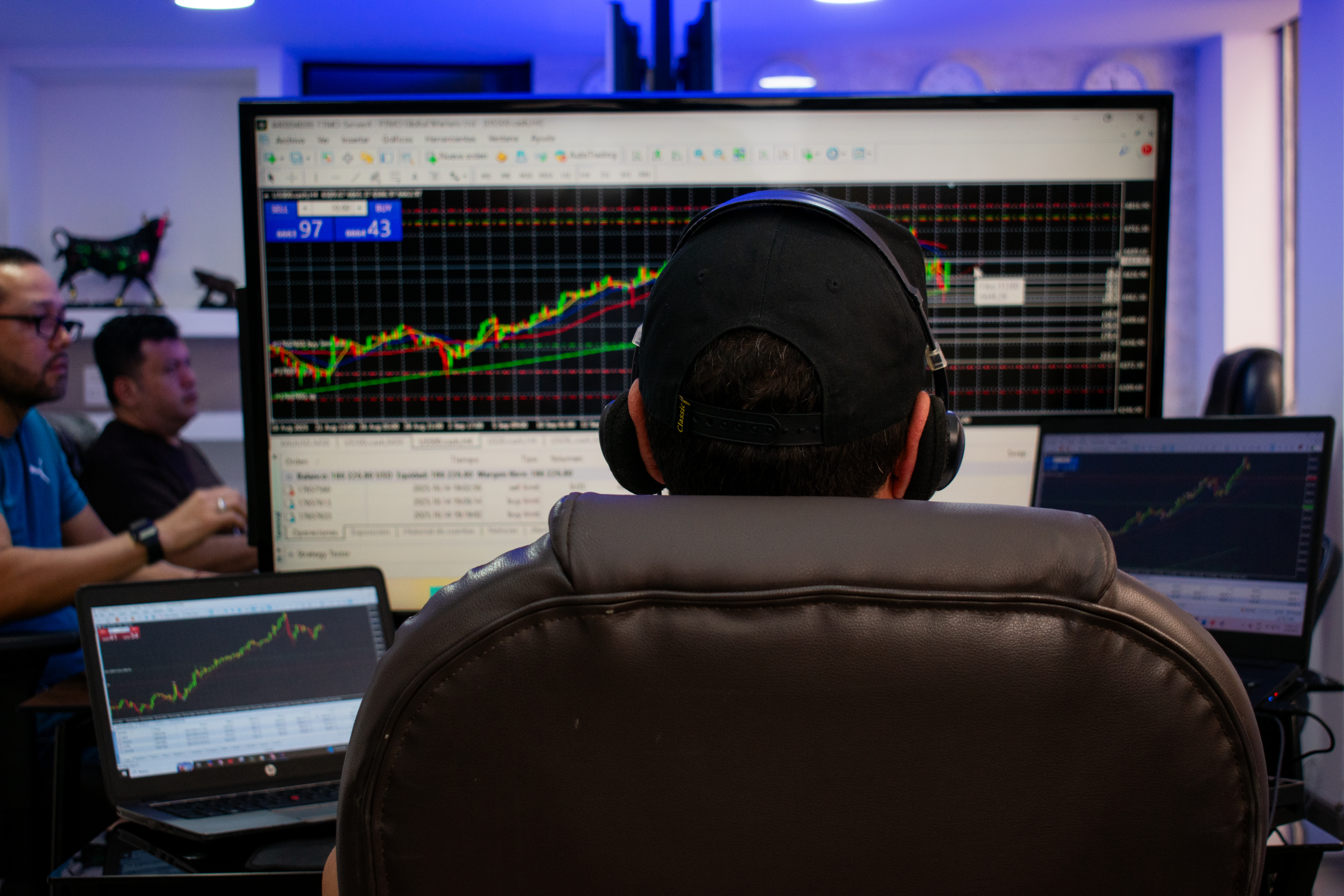 Persona frente a la pantalla de un computador realizando operaciones de Trading