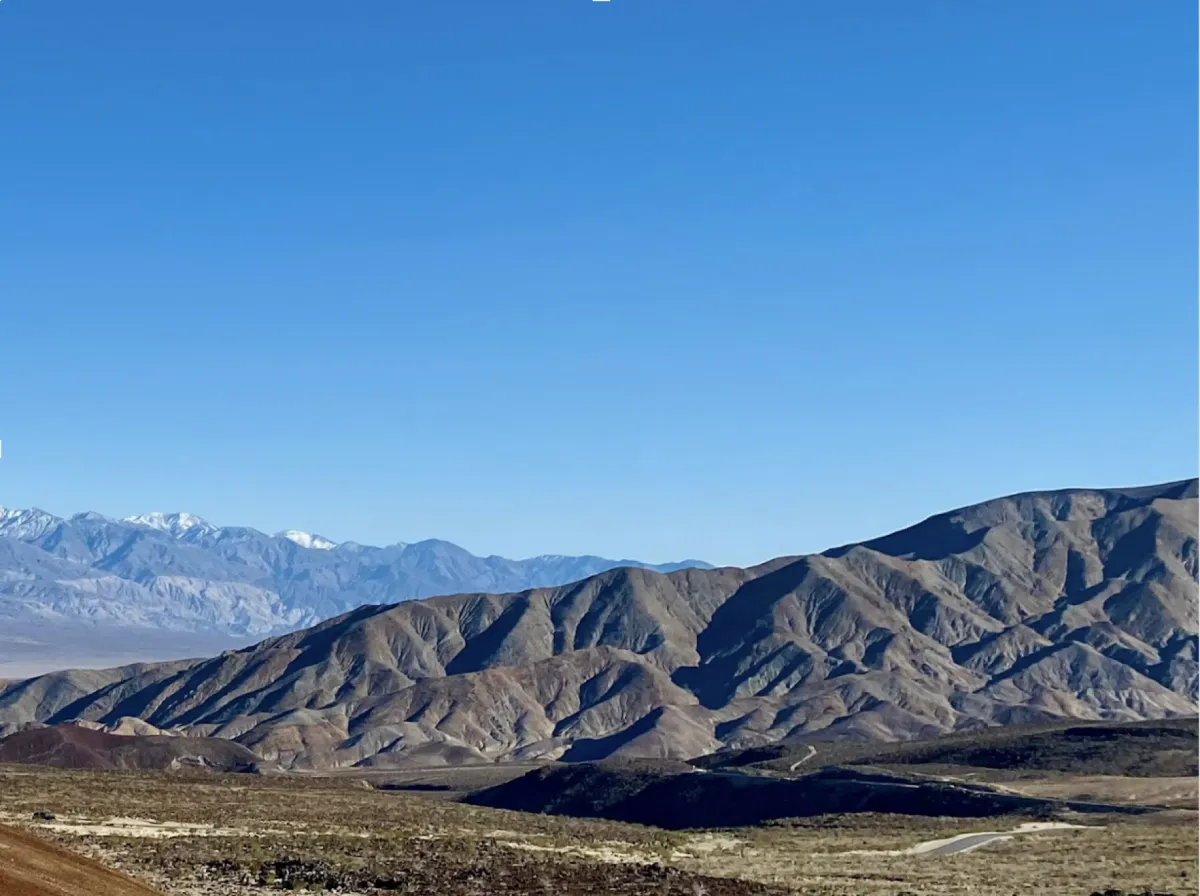 Desert mountain landscape under a cloudless blue sky, evoking the endurance and resilience of July. The layered terrain mirrors nature’s slow, powerful growth—symbolizing the grounded energy of building sustainable systems in business and life