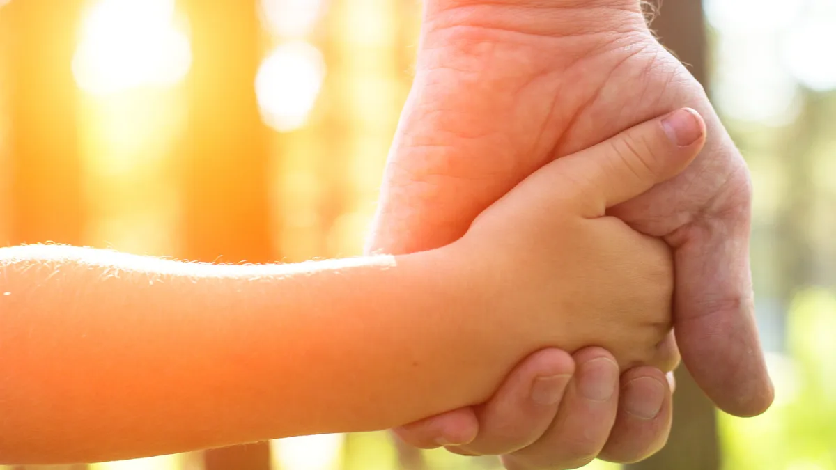 An Adult Holding a Child's Hand