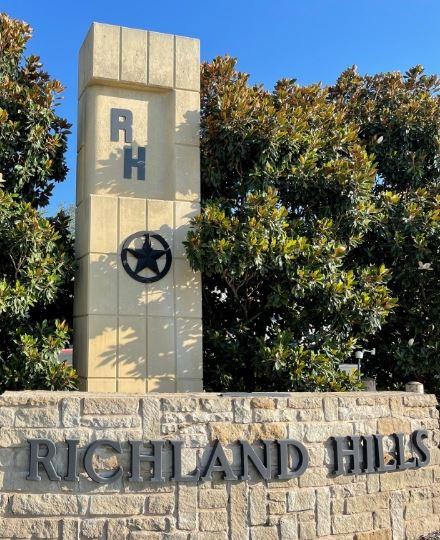 Senior home in Richland Hills, Texas with a Sage Senior Support "Sold As-Is" sign in the yard. A caregiver and elderly parent stand relieved on the porch alongside a supportive real estate professional reviewing paperwork.