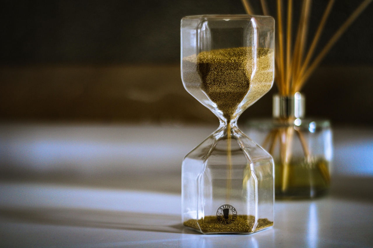 An hourglass symbolizing the limited time and mounting decisions faced by a woman juggling roles as a mother, wife, caregiver, and primary decision-maker for her aging parent’s care.