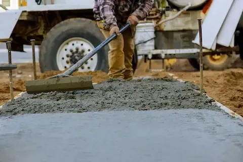 contractor pouring and smoothing concrete