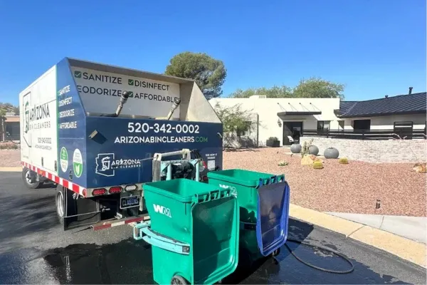 Arizona Bin Cleaners truck cleaning green curbside trash bins in a residential neighborhood.