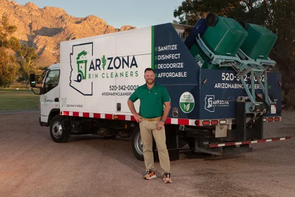 Arizona Bin Cleaners owner standing in front of a branded trash bin cleaning truck with sanitation equipment.