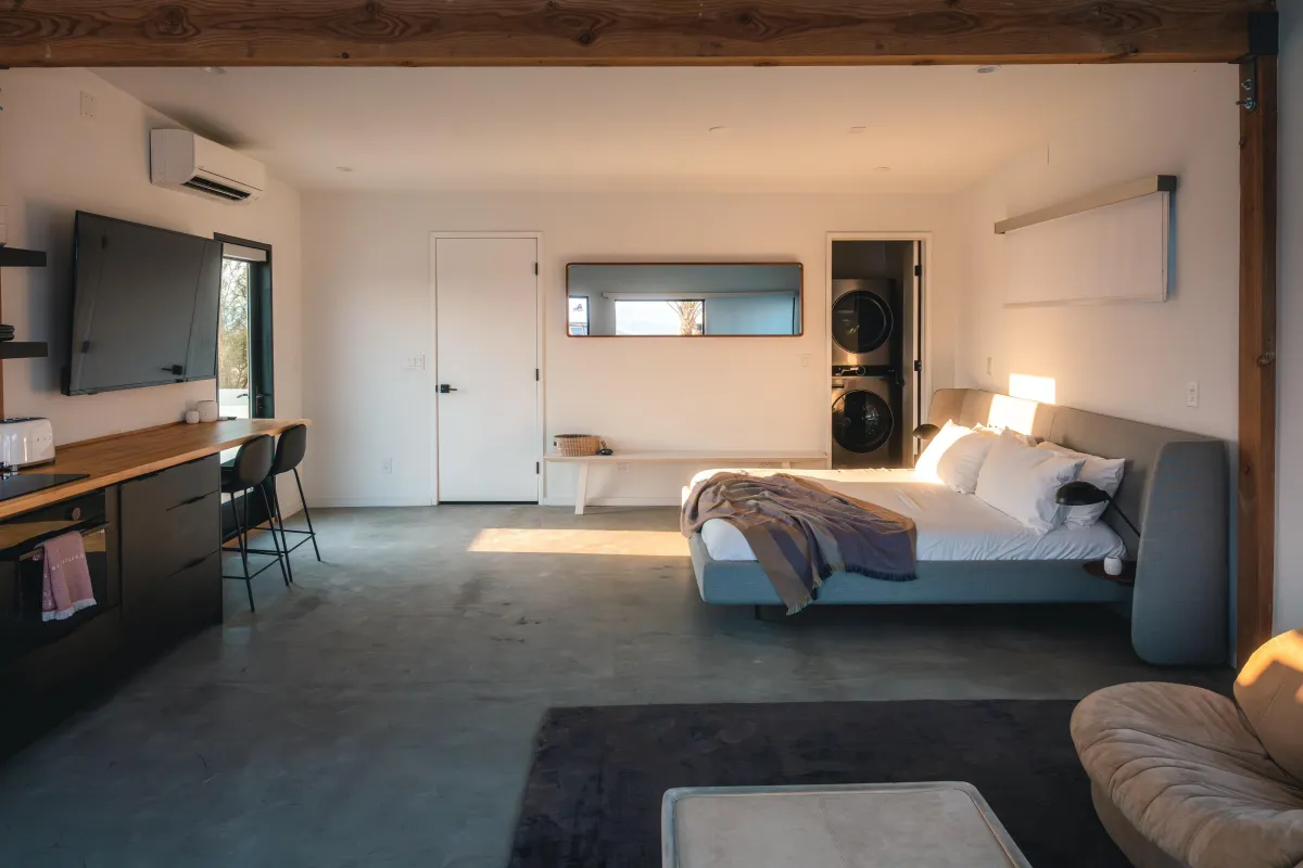 A cozy bedroom featuring a bed, a television, and a desk, creating a comfortable and functional living space.