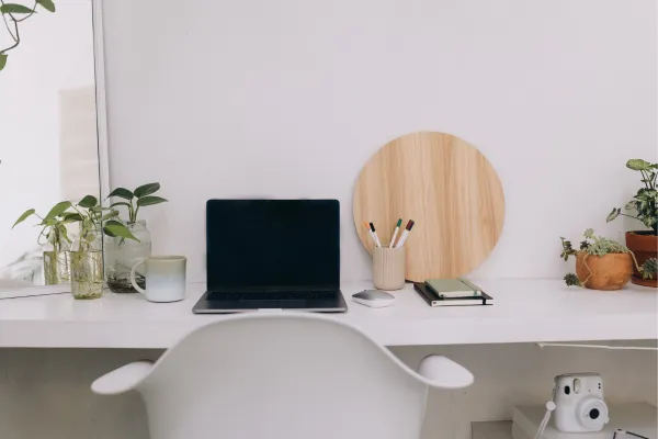 White desk with open computer and plants