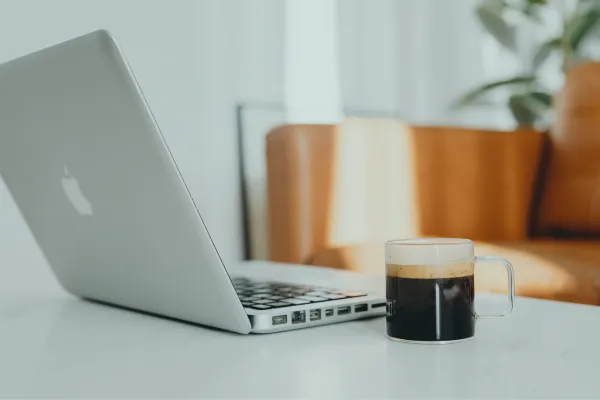 Computer, desk and cup of coffee