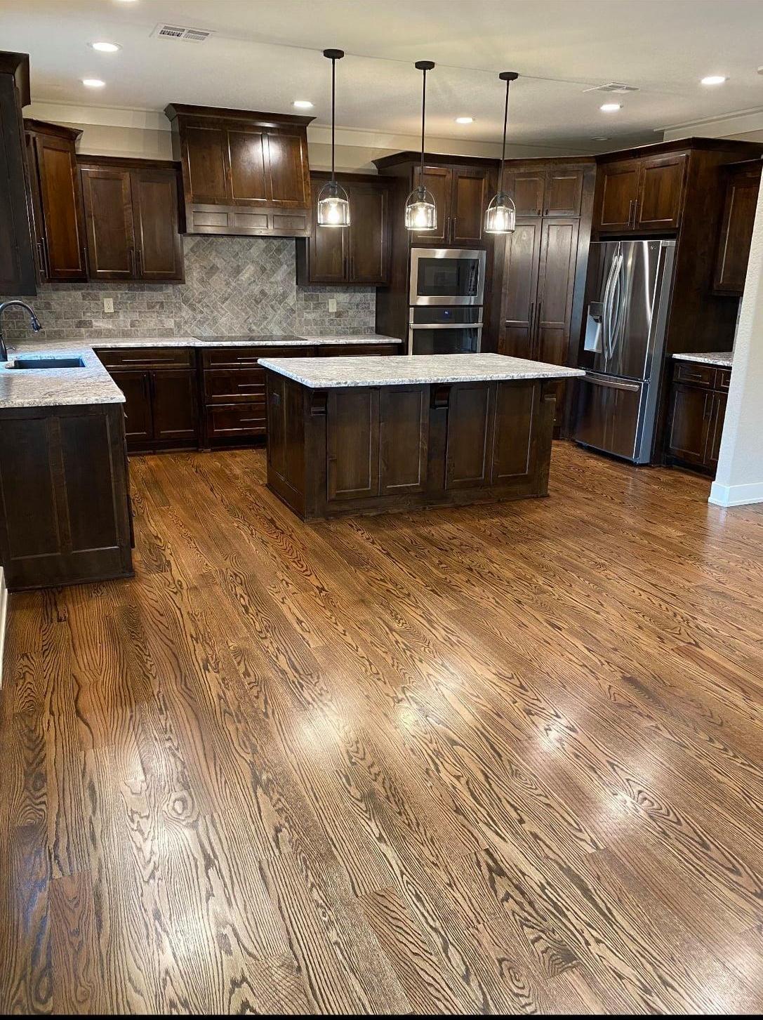 "Contemporary kitchen featuring textured stone tile flooring, stainless steel appliances, and wooden cabinetry."