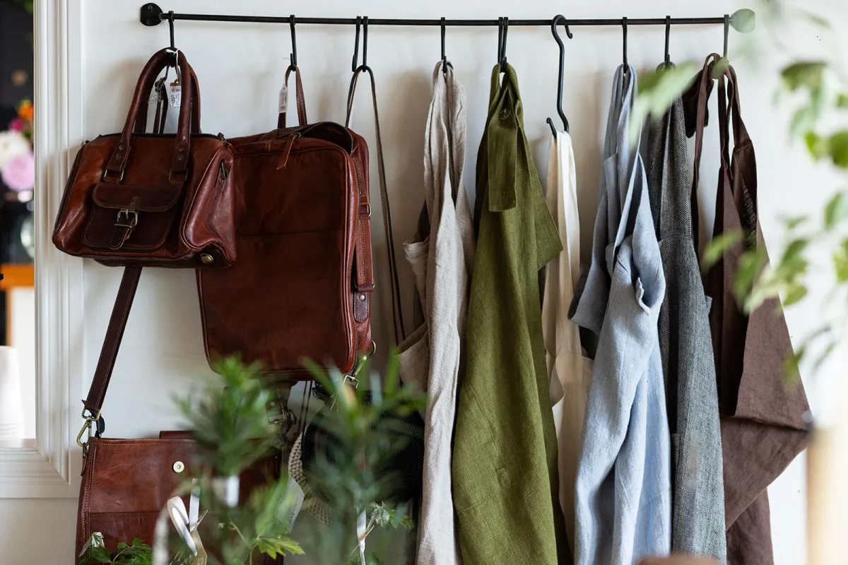 Aprons and leather bags hanging on display at Artisan's Garden in Sooke BC
