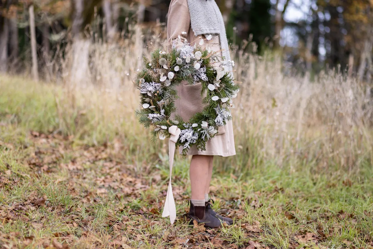 Caitlyn from Deer Leap Florals holding a holiday wreath