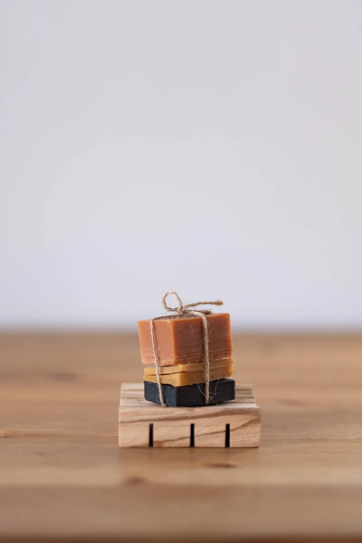 Stack of handmade soap on wooden soap dish by Bilston Creek Farm