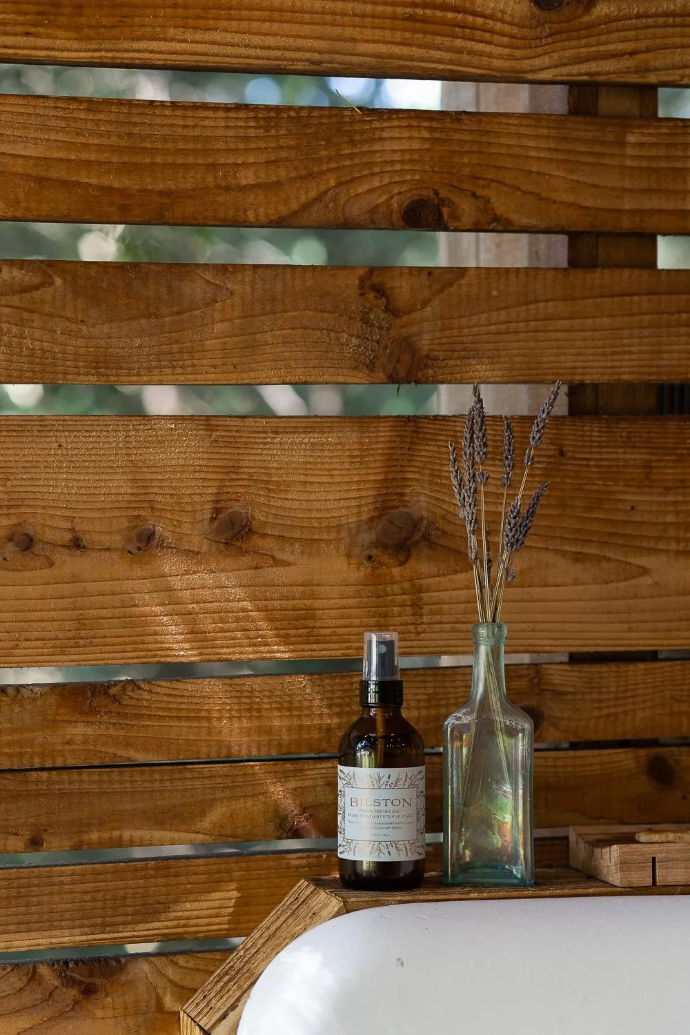 Facial toner by Bilston Creek Farm in an outdoor shower setting