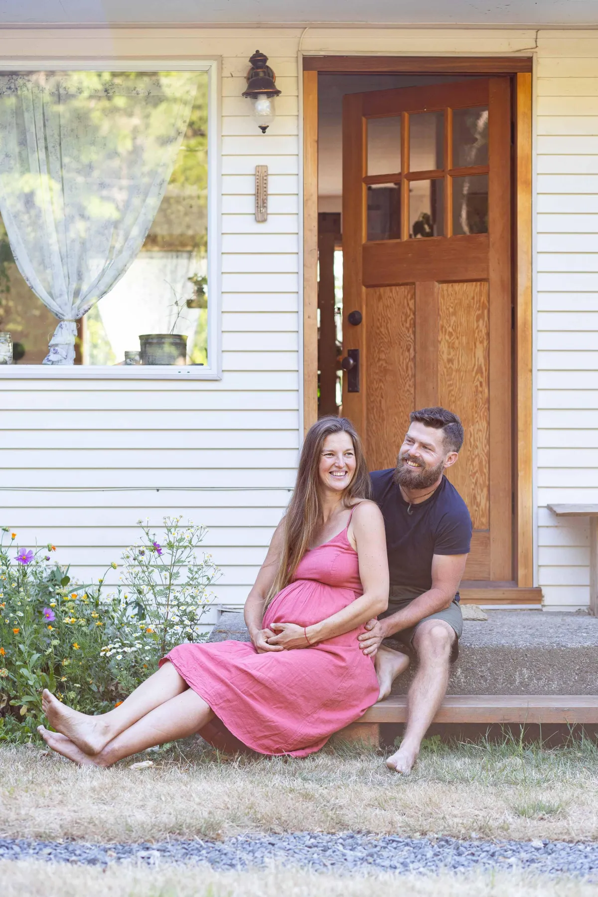 Maternity photo of couple sitting on their front steps in Metchosin BC